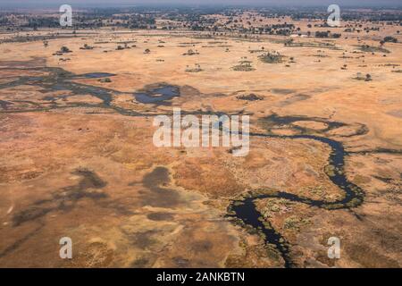 Okavango Delta Antenna, stordimento, colorato paesaggio secco con blu scuro e del fiume Orange savana arida Foto Stock