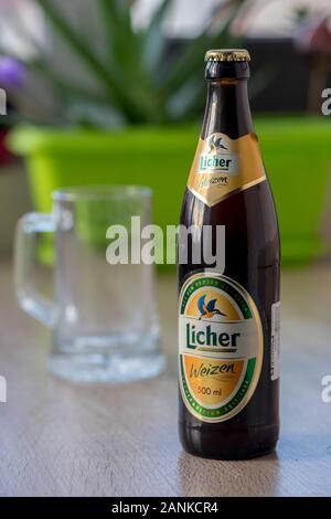 TIMISOARA, Romania - Ottobre 04, 2019: Licher Weizen bottiglia di birra e una pinta di birra su di un tavolo di legno. Realizzato in Germania Foto Stock