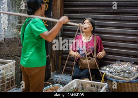 Feng Huang, Cina - Agosto 2019 : donne parlare, chattare e avente una conversazione amichevole sulla strada in città ilvecchio, FengHuang city, Hunan Provinc Foto Stock