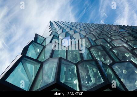 Strutturato facciata honeycomb di concert hall a Reykjavik con cielo blu che riflette off windows- verso l'alto shot con nuvole visibili. L'Islanda, n. persone. Foto Stock