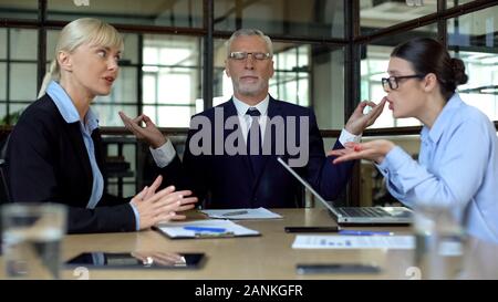 Uomo maturo meditando in ufficio stanco di gridare ai colleghi e riduce lo stress Foto Stock