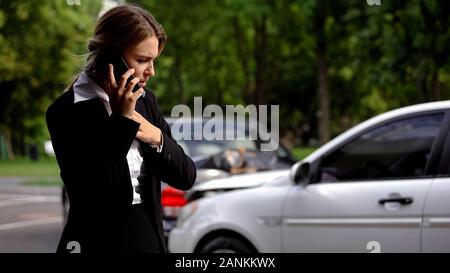 Ha sottolineato il driver femmina parlando telefono collisione auto scena, danni auto, assicurazione Foto Stock
