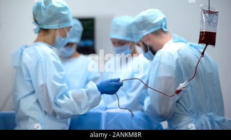 Gocciolamento endovenoso nella camera operativa, la trasfusione di sangue durante la chirurgia, ospedale Foto Stock