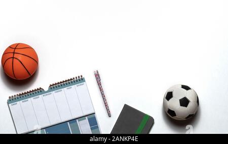 Vista dall'alto in basso di un allenamento settimanale di piano o di programma sportivo con campi da basket e la palla calcio isolati su sfondo bianco. Laici piana, copia dello spazio. Foto Stock