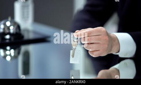 Lavoratore in ricezione dando chiave da camera, controllare in hotel di lusso e di alta qualità Foto Stock