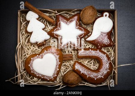 Scatola piena di deliziosa casa natale gingerbread cookies in forma di albero, star, bell, cuore e a ferro di cavallo Foto Stock