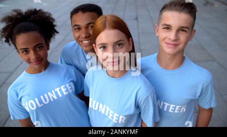 Felice gli studenti mostrando Thumbs up telecamera sorridente, college camp volontario, cura Foto Stock