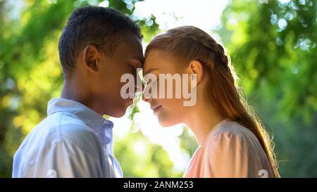 Dolce giovane adolescente di toccare fronte al giorno soleggiato parco, primo rapporto Foto Stock