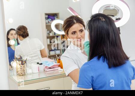 Cosmetologo preparando per trucco permanente, di tatuaggio di labbra nel salone di bellezza Foto Stock