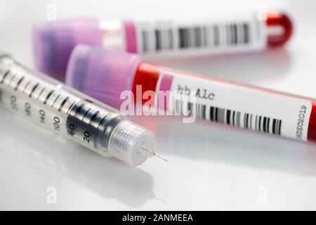 Penna per insulina e di emoglobina A1c sangue provette. La HbA1c prova può asini del controllo del glucosio e regime di insulina efficacia in individui diabetici. Foto Stock