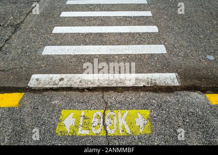 Guardare in entrambe le direzioni a Crosswalk pedonale Foto Stock