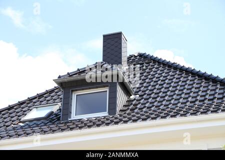 una finestra dormer su un tetto appena coperto Foto Stock