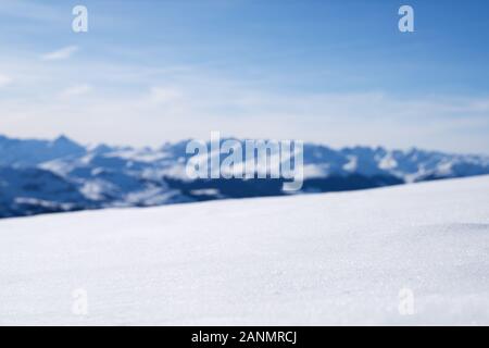 Close-up di paesaggio innevato con sfocato montagne dalle vette innevate a sfondo Foto Stock