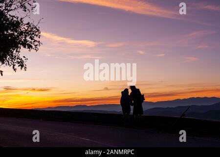 Una coppia guarda l'alba. Storia e dramma si svolgono in o Cebreiro Spagna con i paesaggi galiziani drammatici. El Camino De Santiago, Spagna. Foto Stock