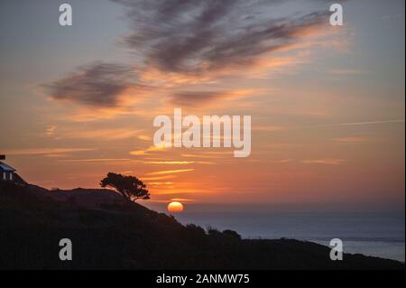 Swansea, Regno Unito. 18 gennaio, 2020. Il sole sorge sulla via costiera che corre da Langland Bay di Mumbles vicino a Swansea oggi su un inverni mattina. Credito: Phil Rees/Alamy Live News Foto Stock