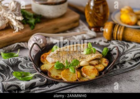 Delizioso pesce con patate arrosto e bio aglio Foto Stock