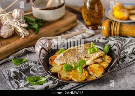 Delizioso pesce con patate arrosto e bio aglio Foto Stock