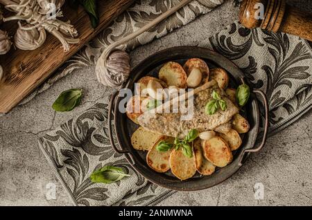 Delizioso pesce con patate arrosto e bio aglio Foto Stock