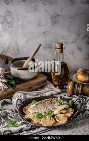 Delizioso pesce con patate arrosto e bio aglio Foto Stock