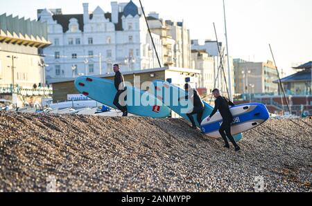 Brighton Regno Unito 18 Gennaio 2020 - Paddle boarders salire fino la spiaggia di Brighton dopo godendo di un inizio di mattina pagaia in bella e soleggiata mattina meteo . Il tempo è previsto rimanere molto più calma dopo le recenti tempeste ma molto più freddo per i prossimi giorni in tutta la Gran Bretagna . Credito: Simon Dack / Alamy Live News Foto Stock