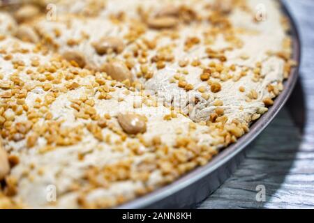 Piatto del Medio Oriente tradizionale gustoso halva a fette su tavola di legno. Dolce iraniano fatto a mano con mandorla. Foto Stock