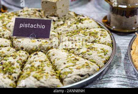 Piatto del Medio Oriente tradizionale gustoso halva a fette su tavola di legno. Dolce iraniano fatto a mano con pistacchio. Foto Stock