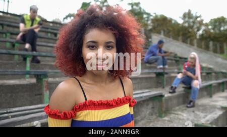 Femmina i capelli rossi studente di college in cerca fotocamera, scomoda, età di nuova generazione Foto Stock