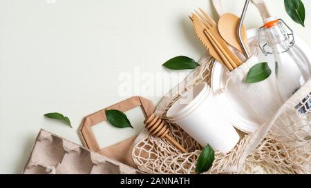 Rifiuti Zero travel set di posate. Vista dall'alto il cotone shopping bag, bicchieri di carta, bottiglia di vetro riutilizzabili e gli utensili di bambù e foglie verdi. Rifiuti Zero, plastica Foto Stock