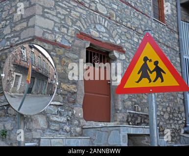 Segnale di traffico, avvertimento persone di essere attenti a persone che attraversano la strada come visto in uno specchio di traffico al villaggio di Kanalia, Karditsa, Grecia. Foto Stock