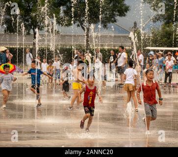 Bambini che giocano in acqua delle fontane al Parco Olimpico di Pechino, Cina Foto Stock