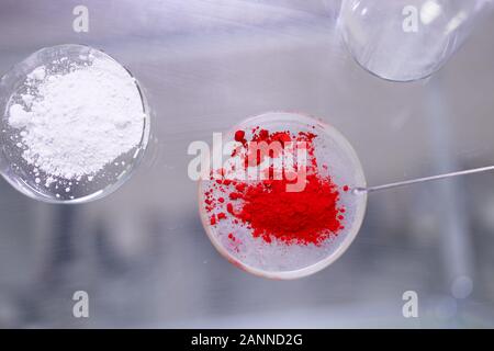 Due tazze di capsule di petri con il rosso e bianco in polvere sul tavolo in laboratorio Foto Stock