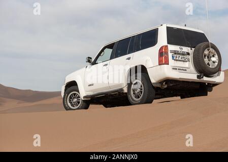 indietro vista della pattuglia bianca nissan super safari salito su una duna di sabbia nel deserto dasht e lut Foto Stock