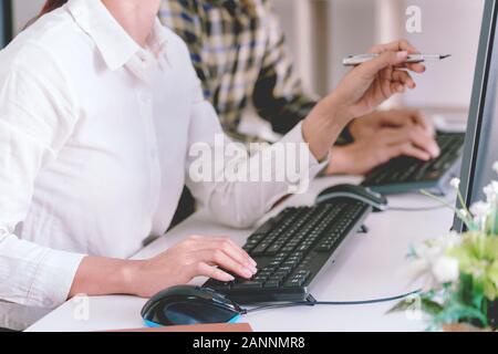 Programmatore pensieroso lavorando sul pc desktop codice di programmazione tecnologie o sito web design in ufficio azienda di sviluppo di software Foto Stock