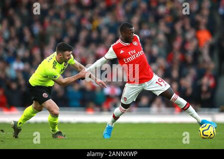 Sheffield United Enda Stevens (sinistra) e dell'Arsenal Nicolas Pepe battaglia per la palla durante il match di Premier League a Emirates Stadium di Londra. Foto Stock