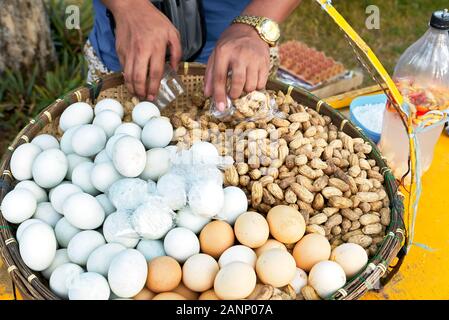 Close-up di arachidi cotti al vapore e bianco e marrone di uova sode e ben presentata in un nativo di vassoio di bambù, venduto da un venditore ambulante nelle Filippine Foto Stock