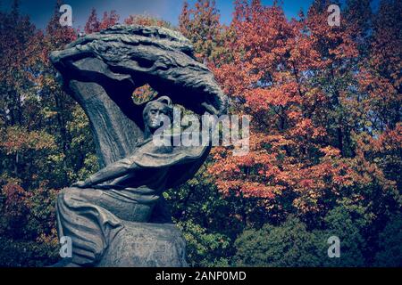 Fryderyk Chopin monumento nella città di Lazienki Park a Varsavia, Polonia, nella soleggiata giornata di caduta con alberi in background in autunno foglie di colore Foto Stock