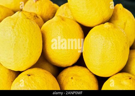 Un mazzetto di tutto mature limoni ammucchiati uno al mercato degli agricoltori in Asia. I frutti pelle mostrano alcune imperfezioni, il segno di un sano agricoltura biologica Foto Stock