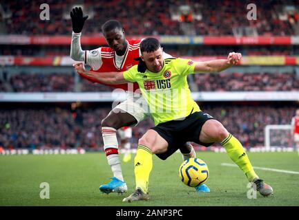 Dell'Arsenal Nicolas Pepe (sinistra) e Sheffield United Enda Stevens battaglia per la palla durante il match di Premier League a Emirates Stadium di Londra. Foto Stock