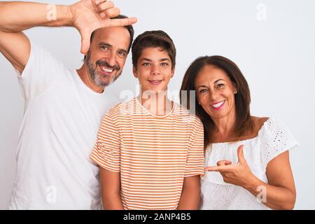 Famiglia di tre, la madre e il padre e il figlio in piedi su bianco isolato sorridente sfondo rendendo il telaio con le mani e le dita con la faccia felice. Creativit Foto Stock