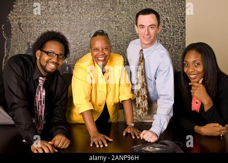 Quattro membri del team in una sala conferenze durante una chiamata telefonica Foto Stock