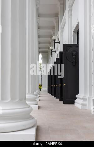 Ingresso con porte nere aperte all'edificio del College of Medicine a Singapore Foto Stock