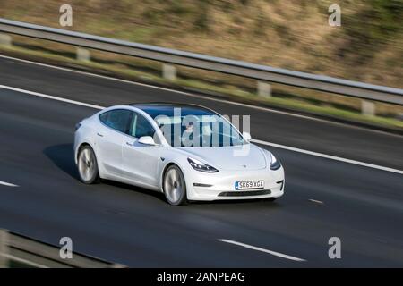 White Tesla modello 3 Performance AWD White Car Electricity Guida sull'autostrada M6 vicino Preston in Lancashire, Regno Unito Foto Stock