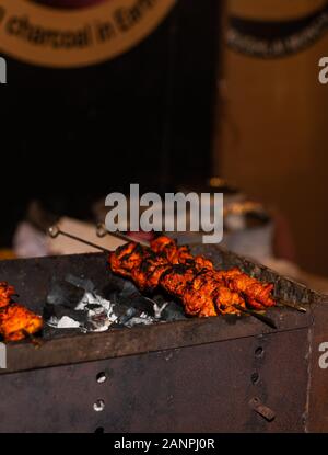 Street food/tradizionale tandoori alla griglia di carni assortite con carbone e fuoco su spiedini Foto Stock