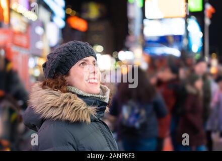 Donna stupita guardando le luci e la folla in Times Square Foto Stock