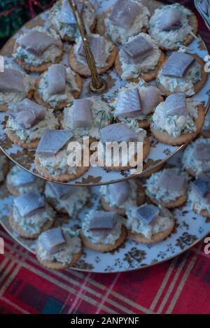 Sandwich di pesce. biscotti con le aringhe. canapes con aringa e formaggio. I cookie con formaggio e Pesce salato. Snack. Fotografia di cibo. Piatto di pesce Foto Stock