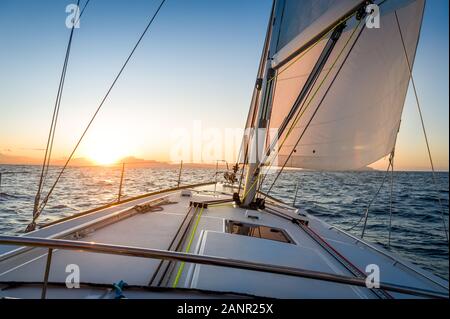 Sailing yacht navigationg al sorgere del sole all'orizzonte.. Mare Mediterraneo, Italia. Foto Stock