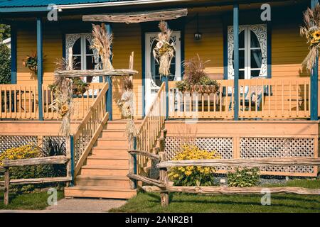 Tipico paese porched casa in arancione e blu. In Canada. La vita rurale del concetto. Foto Stock