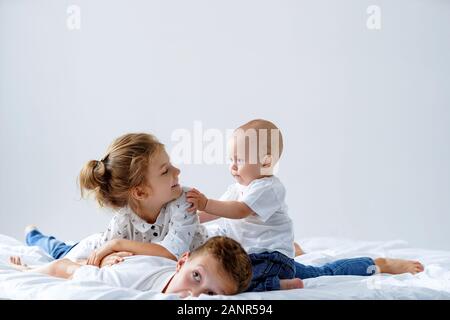 Fratelli e due sorelle rilassante, divertirsi insieme nel letto Foto Stock