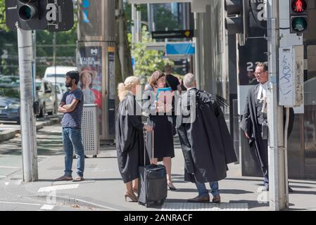 Avvocati e giuristi vestita di nero corte abiti di stand e chat in corrispondenza di un angolo di strada in Melbourne vicino alla Corte Suprema del Victoria, Australia Foto Stock