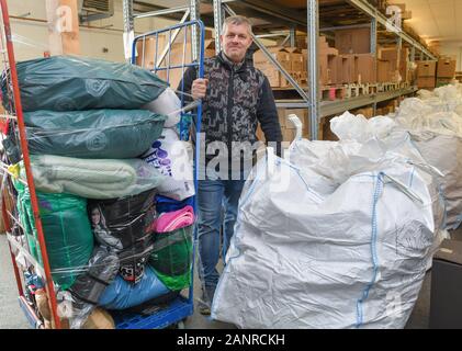 Bad Freienwalde, Germania. Xix gen, 2020. Andreas Steinert, imprenditore, è in piedi in un campo pieno di scatole di cartone e grandi sacchi bianchi di abiti per le persone nei campi profughi sulle isole greche. Il suo appello per le donazioni attivato a livello nazionale la volontà di aiutare. Il primo convoglio con dei vestiti caldi, coperte e tende è sul suo modo. In Bad Freienwalde la collezione continua. (Su 'Iniziativa raccoglie donazioni per i rifugiati in Grecia") Credito: Patrick Pleul/dpa-Zentralbild/ZB/dpa/Alamy Live News Foto Stock